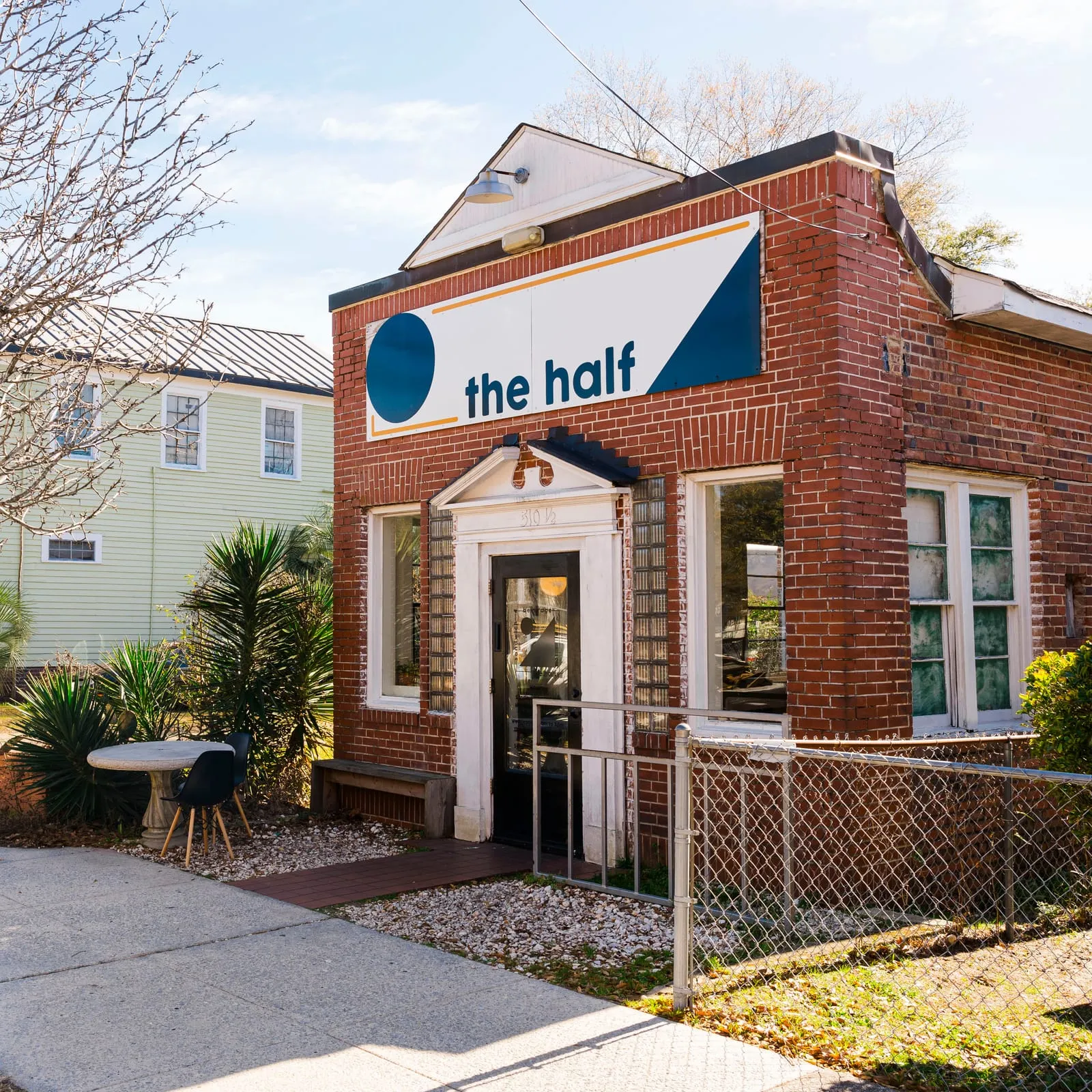 The brick storefront under the Half sign