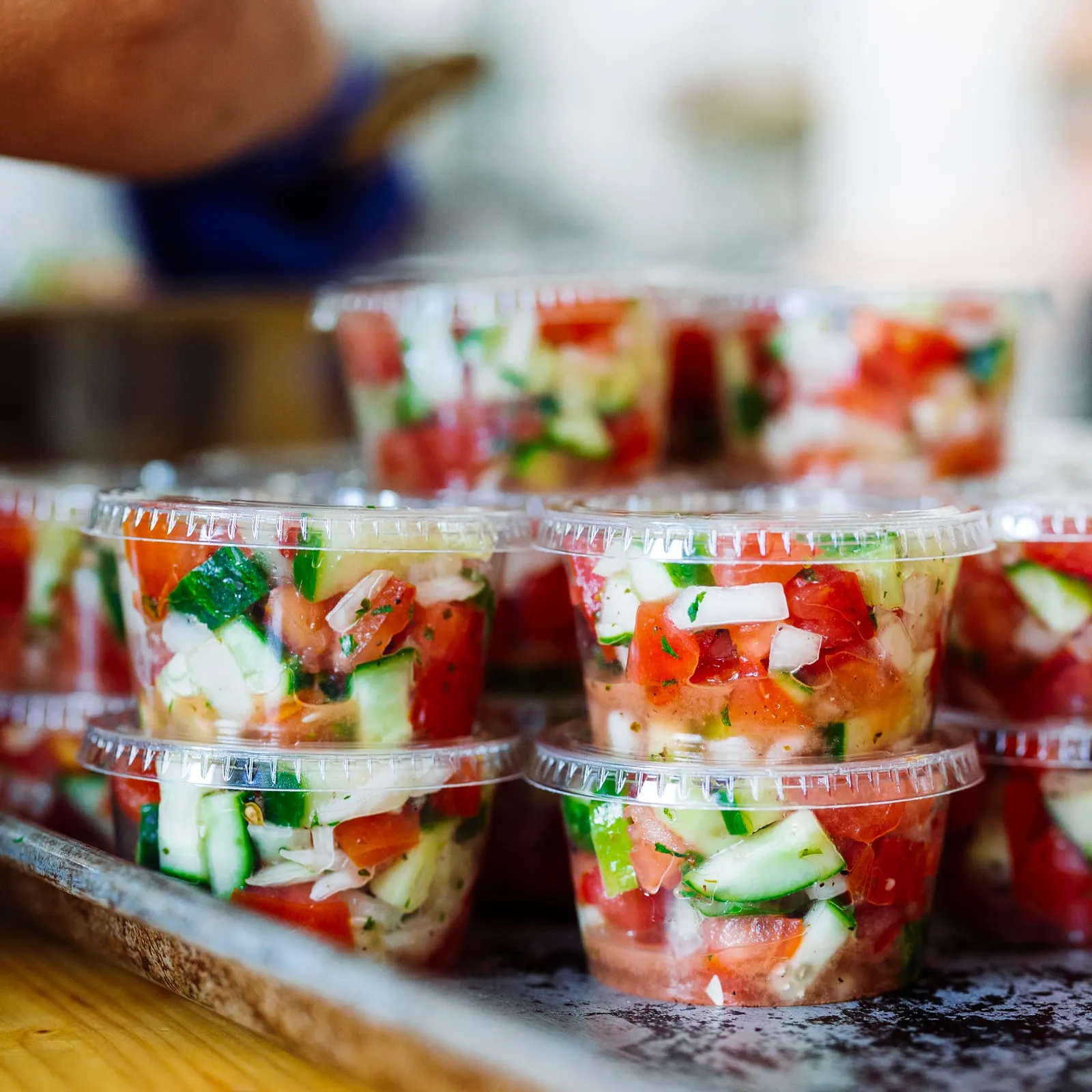 A tray of cucumber tomato onion salad cups