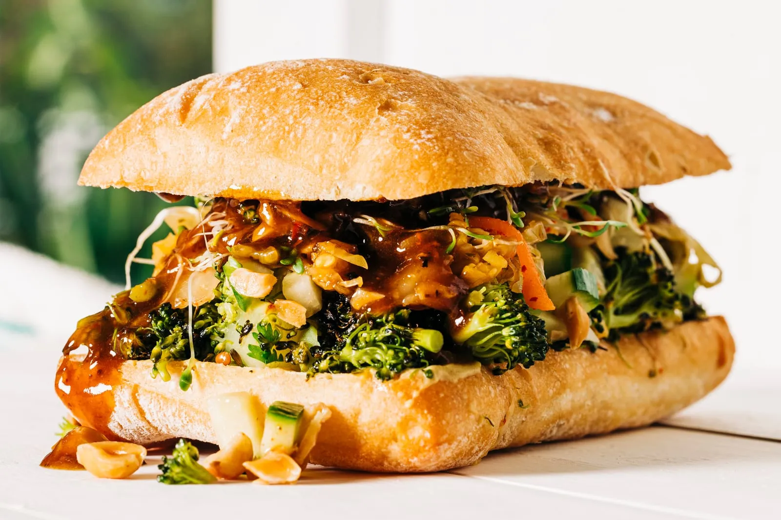 A close crop of a broccoli sandwich on a roll