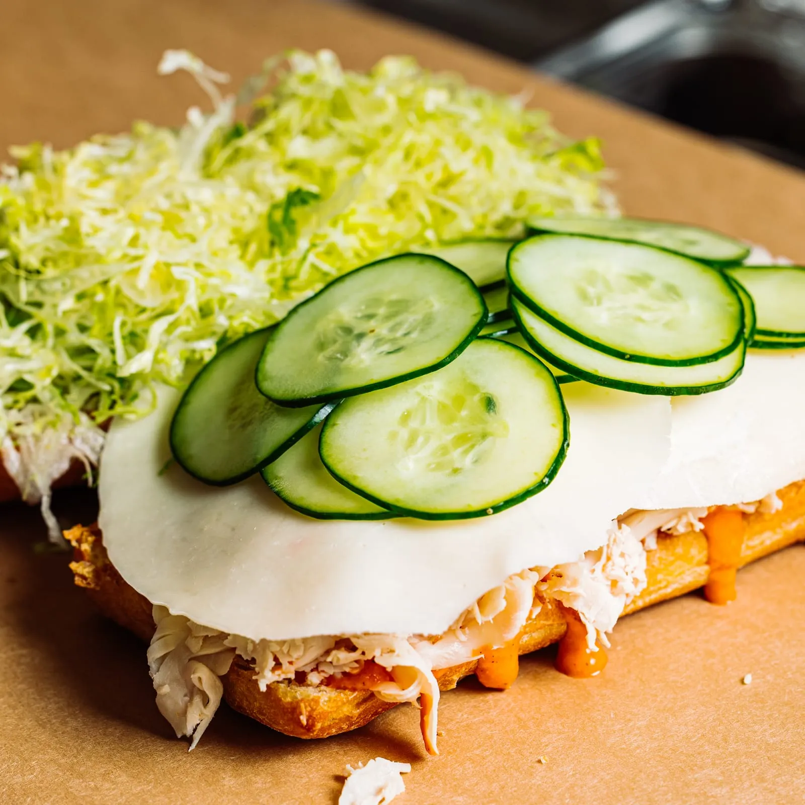 An open turkey sandwich with cucumber and shredduce
