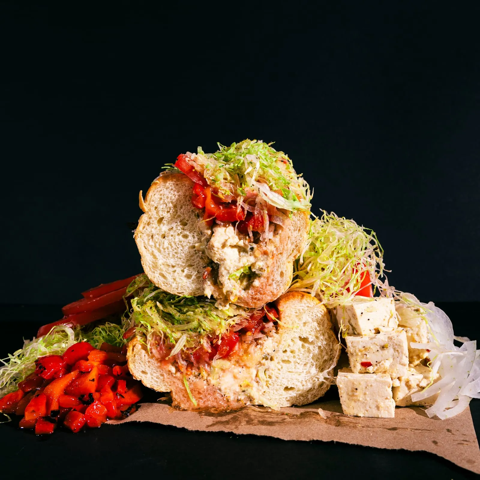 Sandwich pieces stacked against a dark background