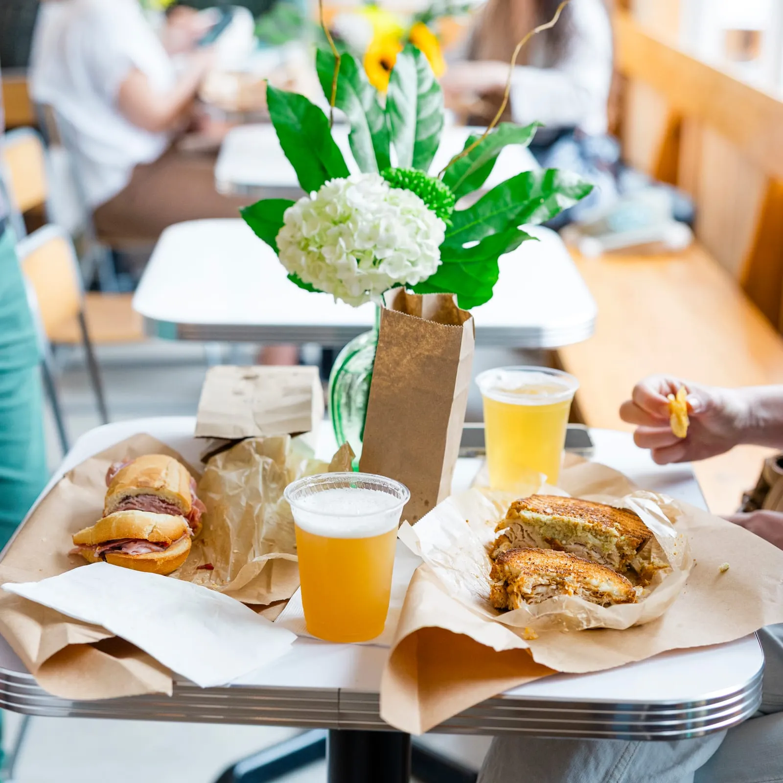 Sandwiches, beers and flowers on a table