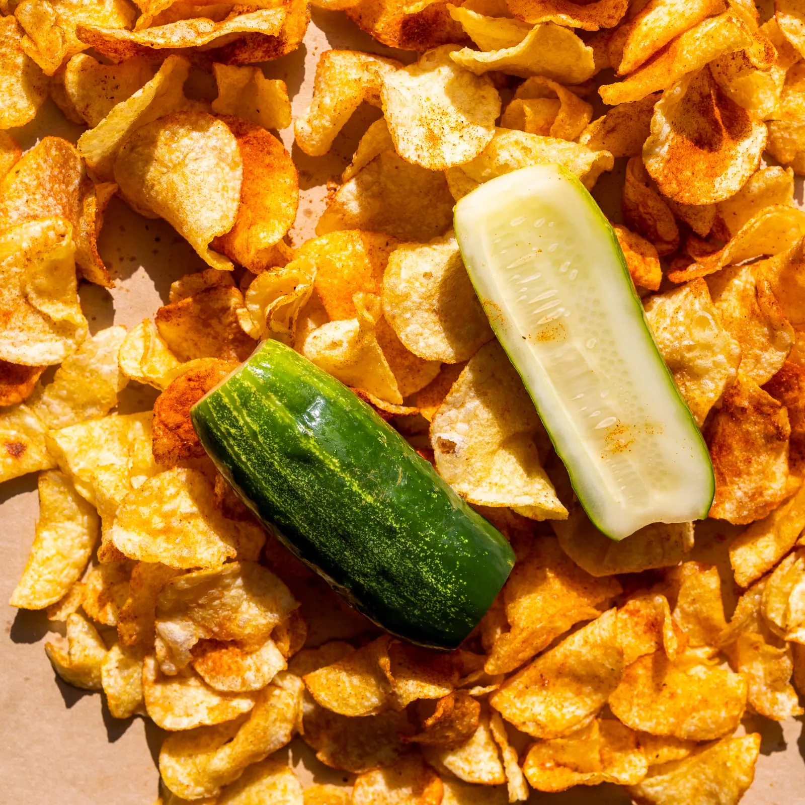 Pickle spears sitting in a pile of chips