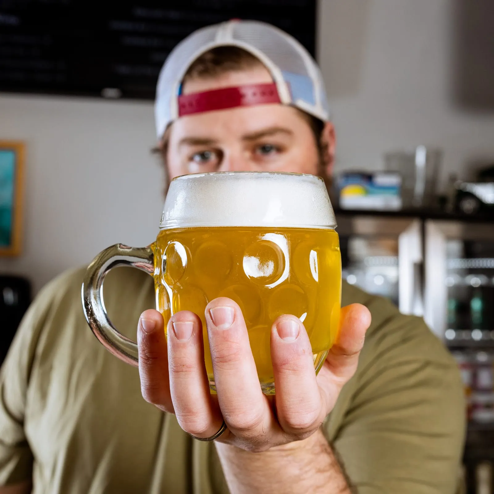 A staff member holding up a full mug